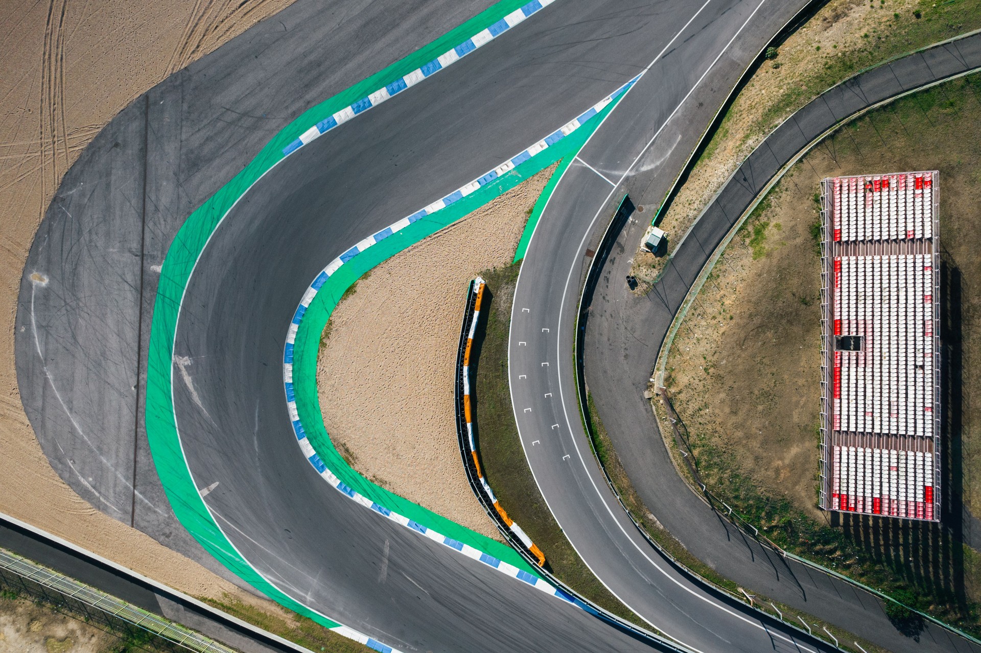 Aerial top down drone view of a racing track with tight turns and hairpins