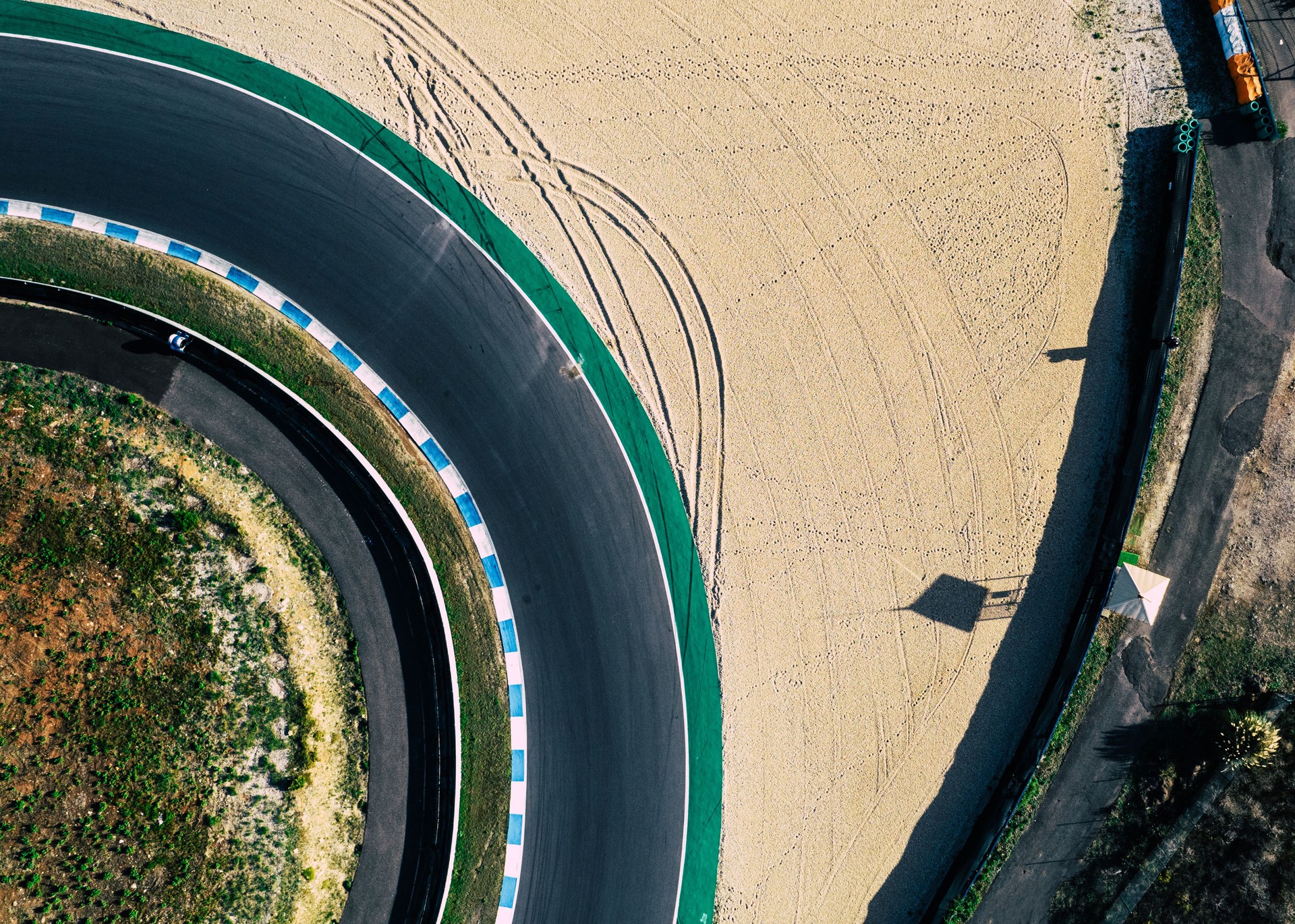 Aerial top down drone view of a racing track with tight turns and hairpins